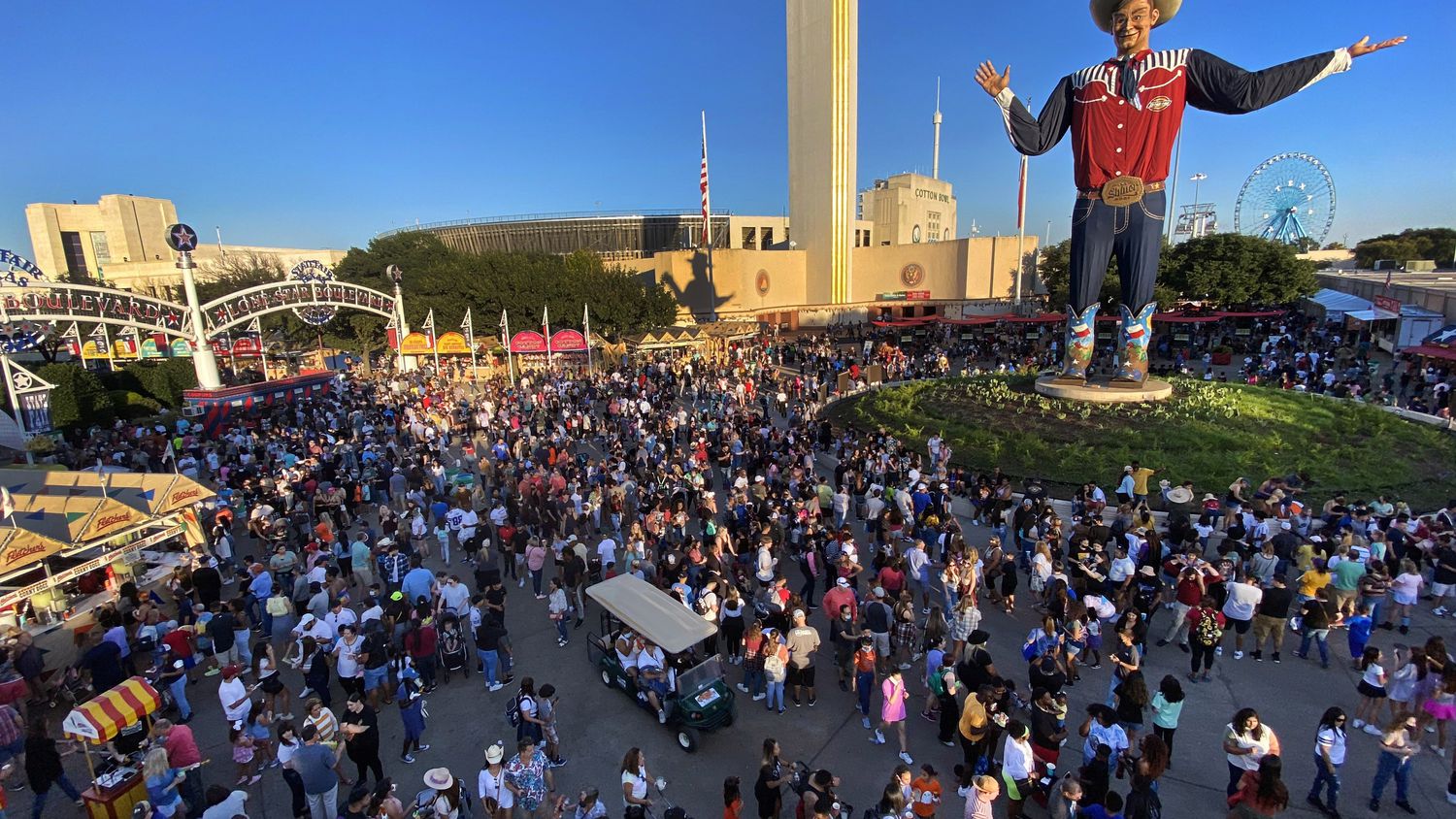 Large crowds fill Big Tex Circle, buying coupons and purchasing food from vendors while...