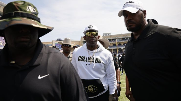 Colorado head coach Deion Sanders, center, leaves the filed after an NCAA college football...